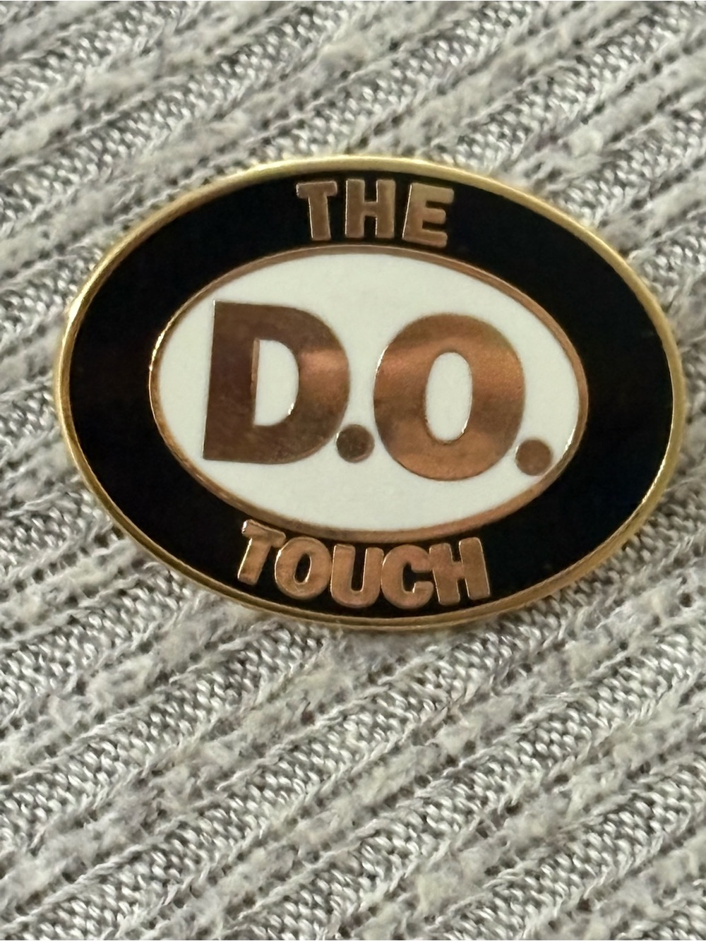 Osteopathic theme gold tone, black & white lapel pin w/ “The D.O. Touch” written